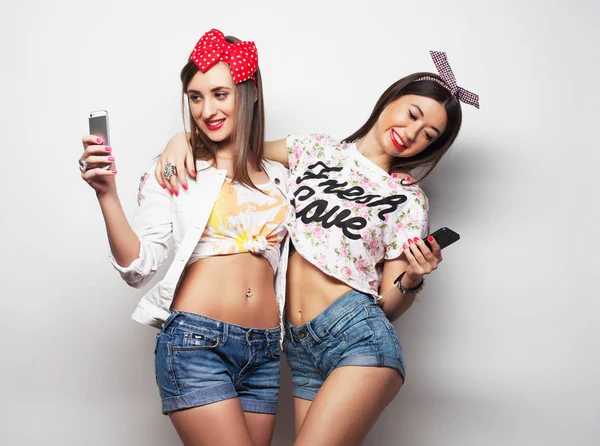 Tecnologia, amizade e conceito de pessoas - dois adolescentes sorridentes tirando fotos com smartphone — Fotografia de Stock