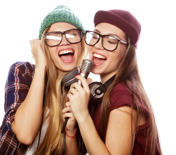 Estilo de vida, felicidad, concepto emocional y de personas: dos chicas de belleza con un micrófono cantando y divirtiéndose —  Fotos de Stock