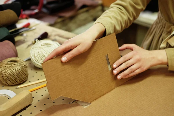 Молодая женщина складывает коробку в швейной мастерской — стоковое фото