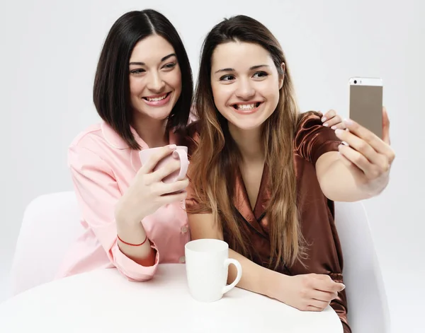 Akıllı telefon alarak selfie ile pijama giyen arkadaşlar veya genç kızlar — Stok fotoğraf