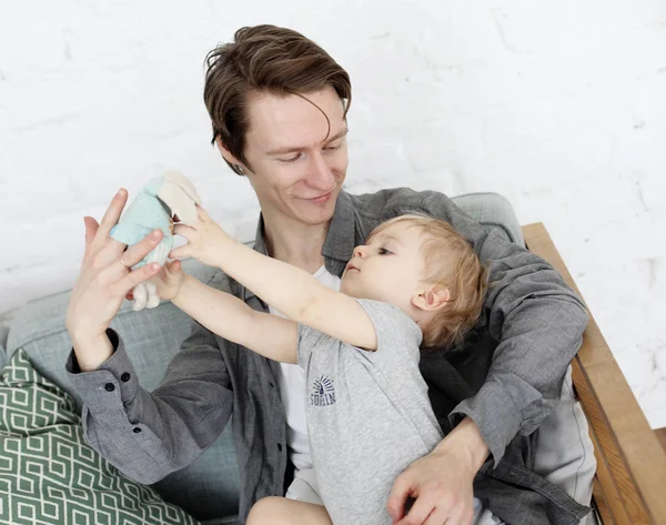 Образ жизни, семья и люди - счастливый молодой отец с годовалым сыном, играющим дома — стоковое фото