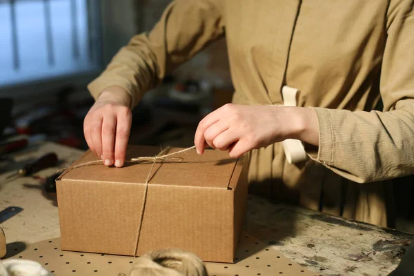 Ung kvinna fäller packbox i sömnad verkstad — Stockfoto