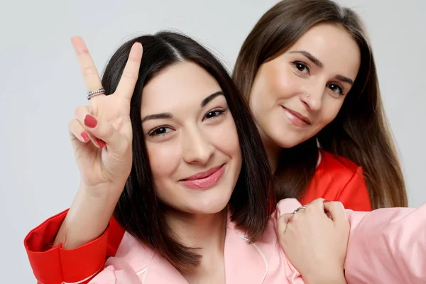 Estilo de vida y el concepto de la gente: dos hermosas chicas vestidas en pijama abrazando y tomando selfies —  Fotos de Stock