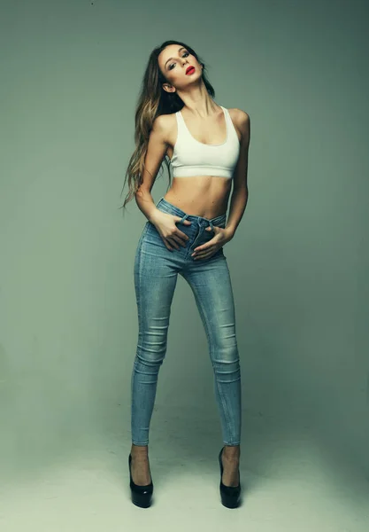 Mode- und People-Konzept: junge Frau in Jeans und BH mit Wind im Haar — Stockfoto