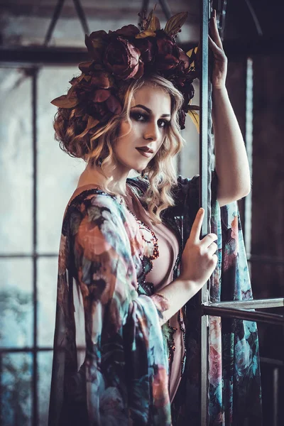 Piękna kobieta w pałacu. Luksusowy moda stylowa dziewczyna w klatce. Sukienka kwiatowa i wieniec z kwiatów. — Zdjęcie stockowe