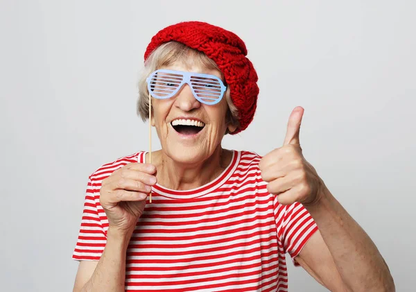 Styl życia, emocje i koncepcja ludzi: zabawna babcia w sztucznych okularach, śmiech i gotowa do zabawy — Zdjęcie stockowe