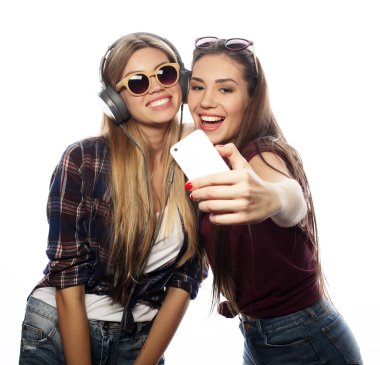 Tahnoloji, duygu ve insan konsepti: Mutlu en iyi arkadaşlar beyaz arka planda akıllı telefondan selfie çekiyor