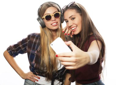 Tahnoloji, duygu ve insan konsepti: Mutlu en iyi arkadaşlar beyaz arka planda akıllı telefondan selfie çekiyor