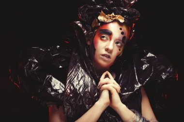 Parlak fantezi makyaj ve kostüm duman bulutları siyah bir arka plan üzerinde poz ile güzel genç kadın. Halloween