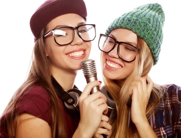 Lifestyle, φιλία και άνθρωποι έννοια: δύο κορίτσια ομορφιά με ένα μικρόφωνο τραγουδώντας και έχοντας τη διασκέδαση — Φωτογραφία Αρχείου