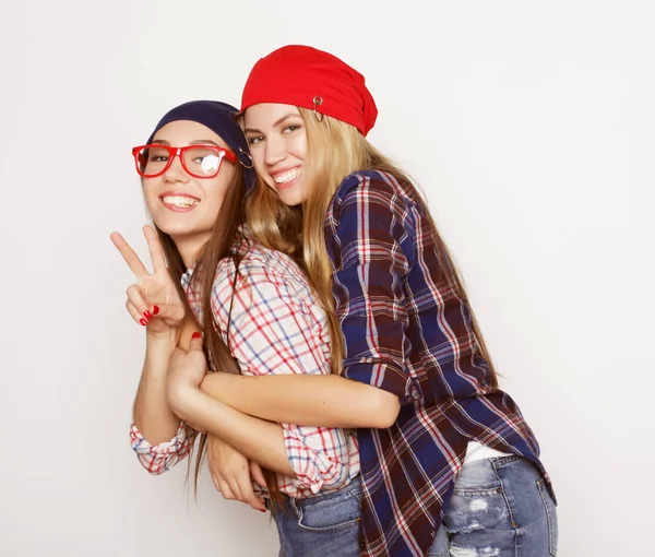 Estilo de vida, la amistad y el concepto de la gente: Dos amigas jóvenes de pie juntos y divirtiéndose. Estilo Hipster . —  Fotos de Stock