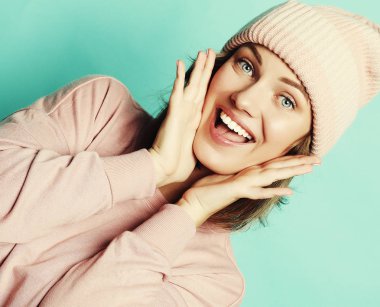 Pembe şapka ve süveter giyen mutlu genç bir bayan. 