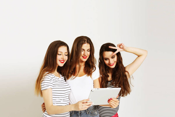  three smiling teenage girls with tablet pc computers
