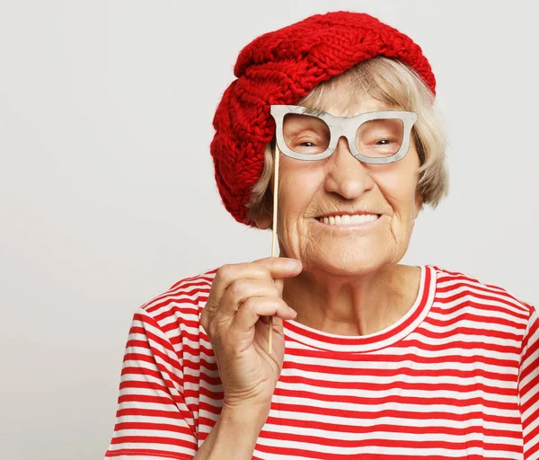 Lifestyle, emotion and people concept: funny grandmother with fake glasses, laughs and ready for party — Stock Photo, Image