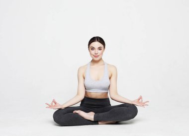 Yoga yapan çekici kadının portresi, açık gri arka plan üzerinde pilates. Sağlıklı yaşam tarzı ve spor konsepti.