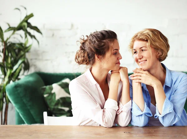 Lifestyle, familie en mensen concept: Gelukkige jonge vrouw en haar moeder thuis — Stockfoto