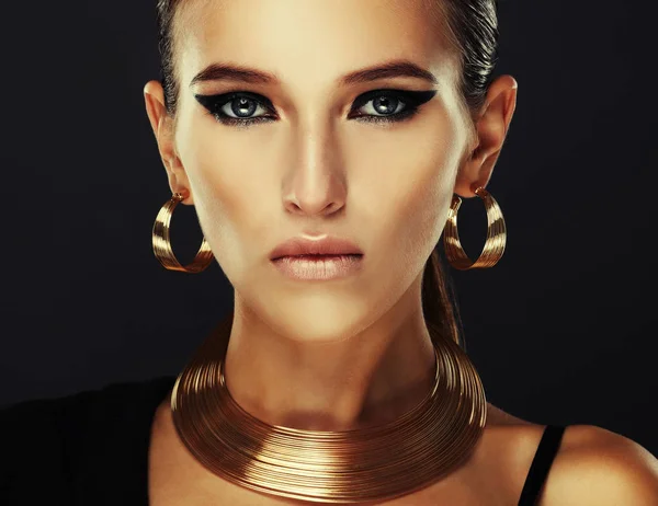 Красивая женщина с вечерним макияжем и золотыми украшениями . — стоковое фото
