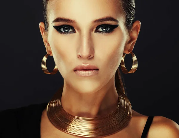 Mooie vrouw met avond make-up en gouden sieraden. — Stockfoto