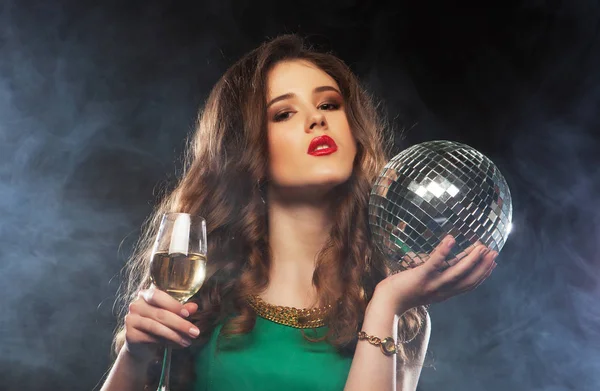 Bir kadeh beyaz şarap ve disko topu ile güzel seksi kadın — Stok fotoğraf