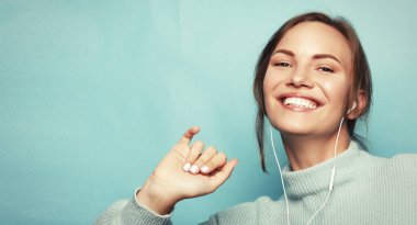 Kulaklıklı güzel genç bir kadın müzik dinliyor. 