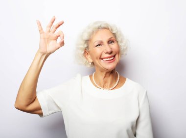 Yaşam tarzı, duygu ve insan kavramı: yaşlı kadın beyaz arka plan üzerinde ok işareti gösteren