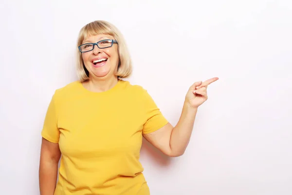 Életmód, érzelem és az emberek fogalma-boldog Senior nő mutat valamit a fehér háttér — Stock Fotó