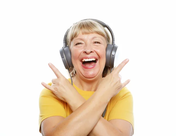 Funny old lady listening music and showing thumbs up. Isolated on white. — Stock Photo, Image