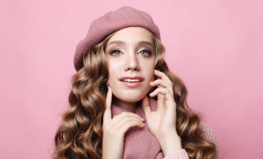 Uzun dalgalı saçlı, pembe bereli, atkılı ve gözlüklü güzel bir bayan manken.