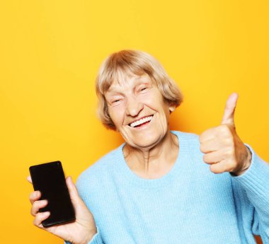 Yeni akıllı telefonlu olgun bir kadının resmi..
