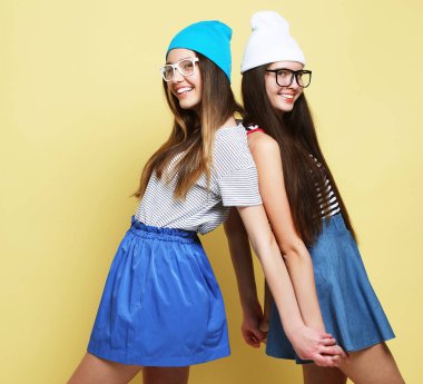 Tam vücut portre sarı arka plan üzerinde iki hippi kız