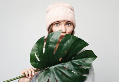 genç kadın büyük bir tropikal çiçek bir yaprak tutan ve gülümseyen