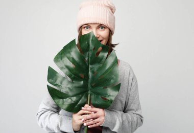 genç kadın büyük bir tropikal çiçek bir yaprak tutan ve gülümseyen