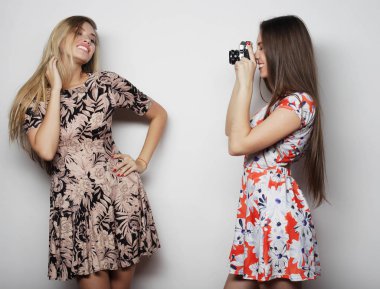 dostluk ve insan kavramı: İki genç kız arkadaş birlikte ayakta ve kamera ile fotoğraf çekmek