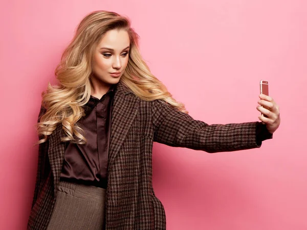 Retrato de mujer rubia sonriente beautifu en ropa casual con maquillaje perfecto con teléfono inteligente —  Fotos de Stock