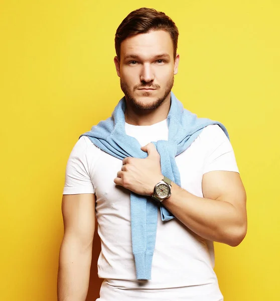 Handsome young man, fashion model. Posing over yellow wall. Lifestyle and fashion concept. — Stock Photo, Image