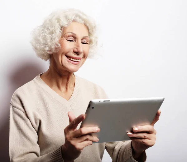 Счастливая зрелая женщина с помощью планшета, общается с детьми и внуками — стоковое фото