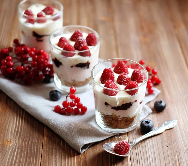 Healthy breakfast - yogurt with fresh berries and muesli served in glass jar, on wooden background — Stock Photo, Image