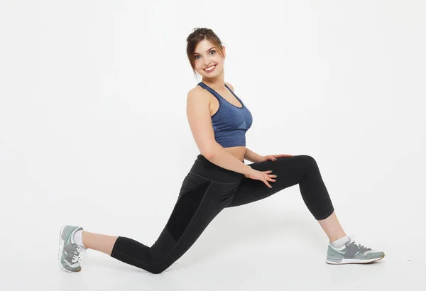 Sport, livsstil och människor koncept: Aktiv kvinna gör fitness övningar över vit bakgrund — Stockfoto