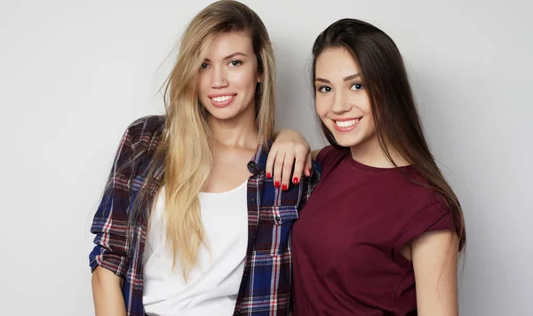 Lifestyle, friendship and people concept: Two young girl friends standing together and having fun. Hipster style. — Stock Photo, Image