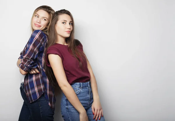 Lifestyle, friendship and people concept: Two young girl friends standing together and having fun. Hipster style. — Stock Photo, Image