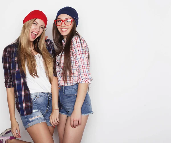 Estilo de vida, la amistad y el concepto de la gente: Dos amigas jóvenes de pie juntos y divirtiéndose. Estilo Hipster . —  Fotos de Stock