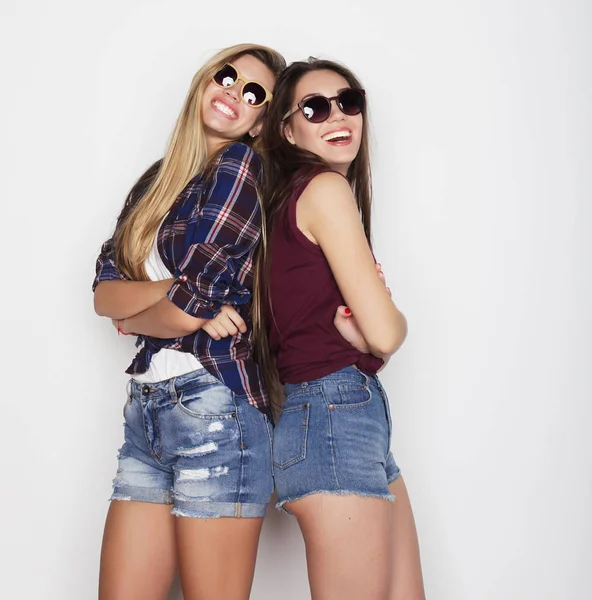 Estilo de vida, la amistad y el concepto de la gente: Dos amigas jóvenes de pie juntos y divirtiéndose. Estilo Hipster . — Foto de Stock