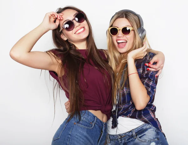 Estilo de vida, la amistad y el concepto de la gente: Dos amigas jóvenes de pie juntos y divirtiéndose. Estilo Hipster . —  Fotos de Stock