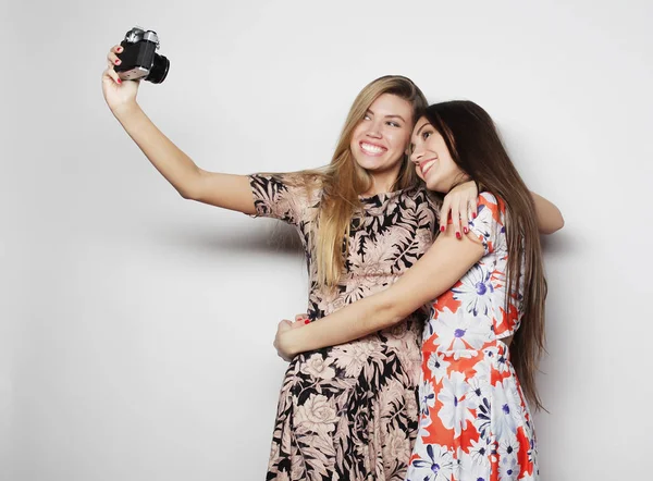 Dostluk ve insan kavramı: İki genç kız arkadaş birlikte ayakta ve kamera ile fotoğraf çekmek — Stok fotoğraf