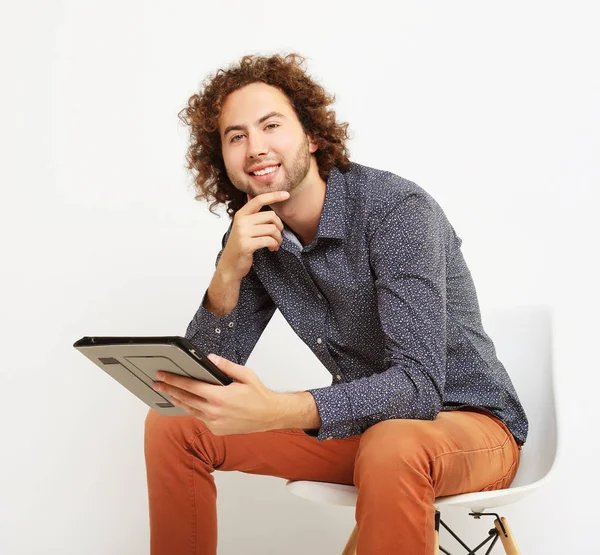 Lycklig casual man på en stol med en TabletPC, — Stockfoto