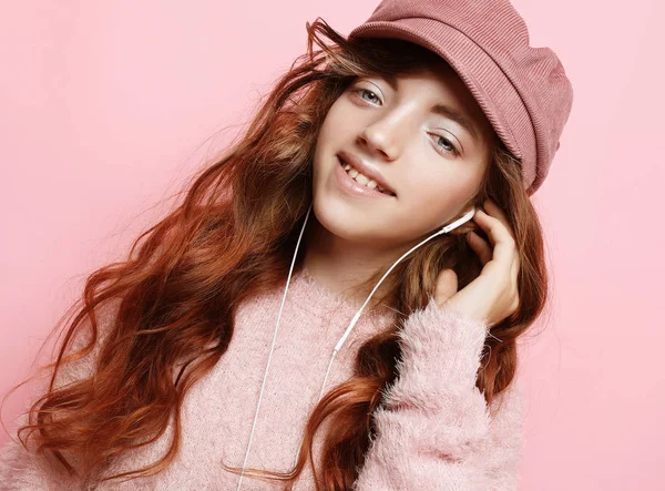 Εικόνα της ευτυχής έφηβος κορίτσι στέκεται απομονωθεί σε ροζ φόντο, σε ροζ καπέλο και πουλόβερ. — Φωτογραφία Αρχείου