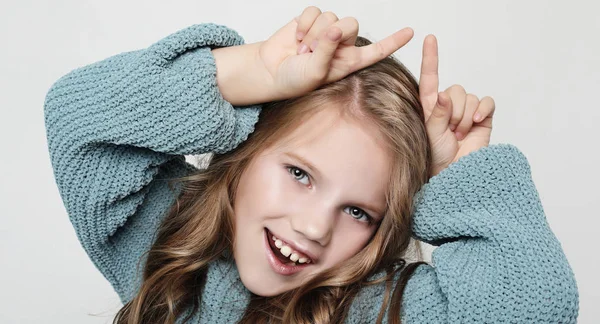 Ritratto di bambino felice positivo con i capelli ricci, tenendo le dita indice sopra la testa, imitando le corna e sorridendo — Foto Stock