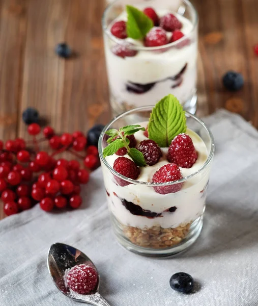 Café da manhã saudável - iogurte com bagas frescas e muesli servido em jarra de vidro, em fundo de madeira — Fotografia de Stock