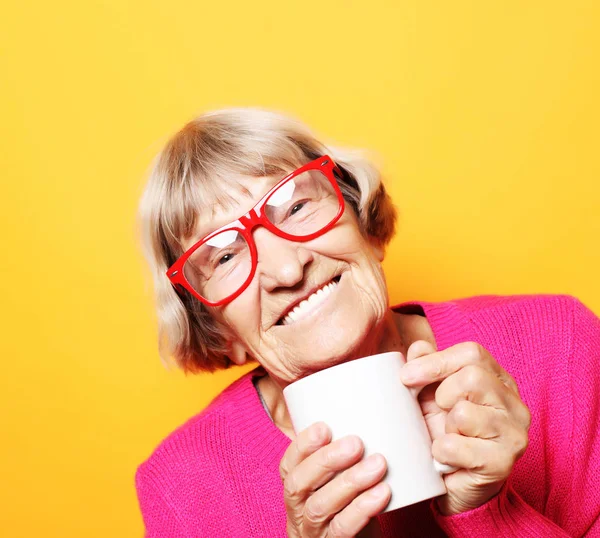 Portret staruszki uśmiechniętej, trzymającej filiżankę kawy, herbatę — Zdjęcie stockowe