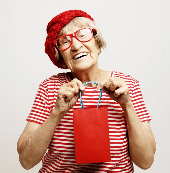 Životní styl, dovolená a lidé koncept: starší žena s dárkovou taškou. — Stock fotografie